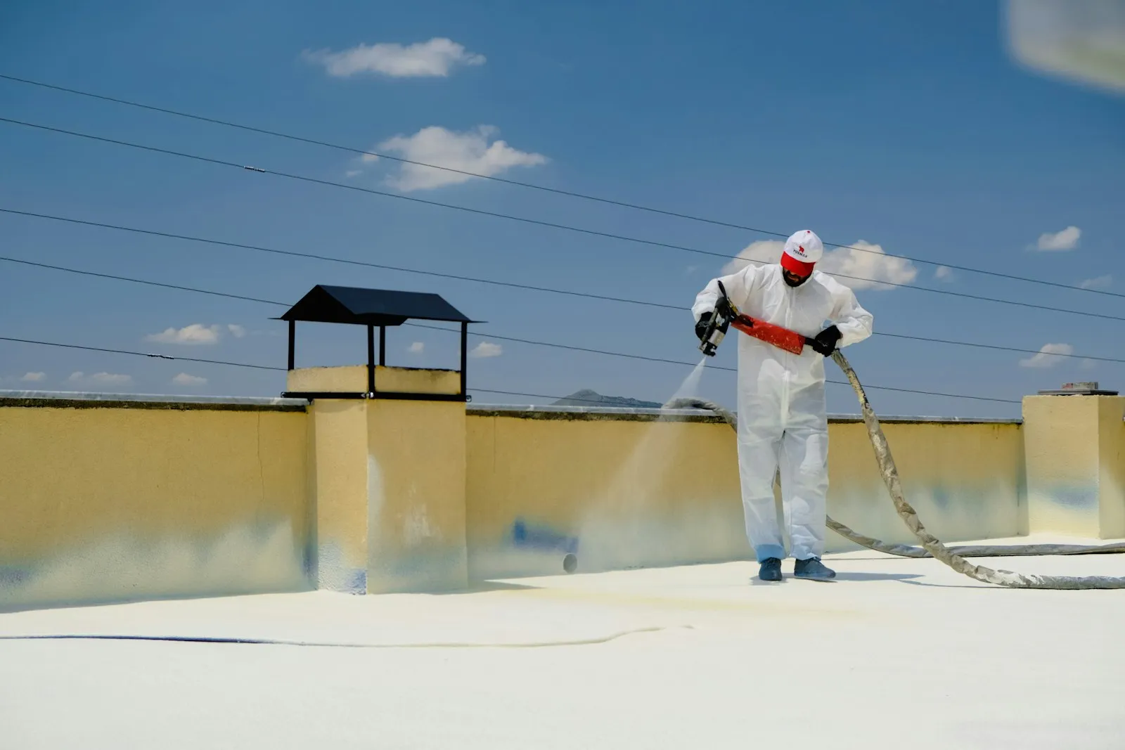 Worker applying protective treatment to a roof surface